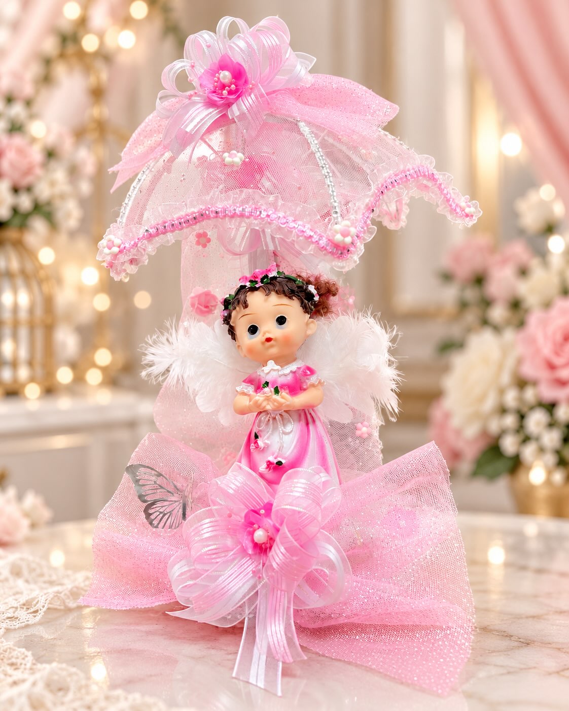 Recuerdo de bautizo con muñeca bajo sombrilla de encaje y lazos rosados